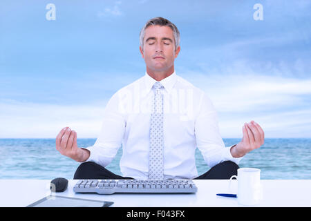 Immagine composita di imprenditore zen meditando in lotus pongono Foto Stock