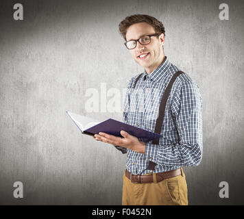 Immagine composita di geeky studente la lettura di un libro Foto Stock