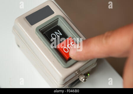 Maschio di spinta a mano di colore rosso sul pulsante off closeup. Foto Stock