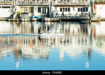 Single scull barca a remi sul fiume a Henley on Thames nelle prime ore del mattino la luce del sole. Oxfordshire, Inghilterra Foto Stock