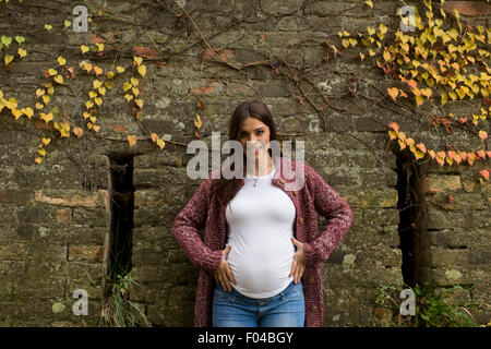Giovane donna incinta in autunno park Foto Stock