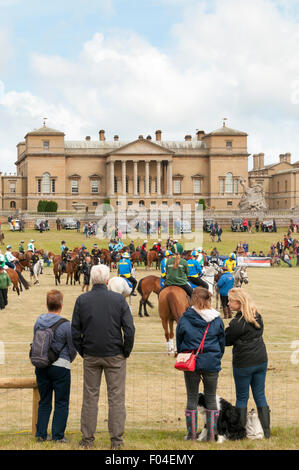 La gente a guardare i giochi montato nel Grand ghiera anteriore di Holkham Hall a Holkham Country Fair. Foto Stock