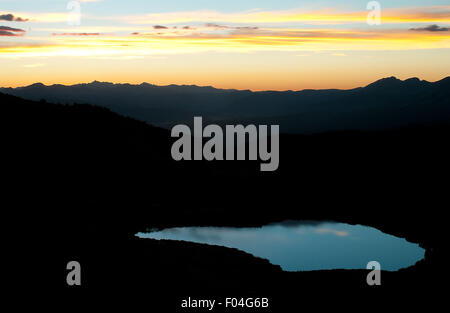 Un alpine tarn riflette la luce della sera come al tramonto si deposita sopra la valle di Gunnison come visto da pioppi neri americani passano vicino a Buena Vista, Colorado. Foto Stock