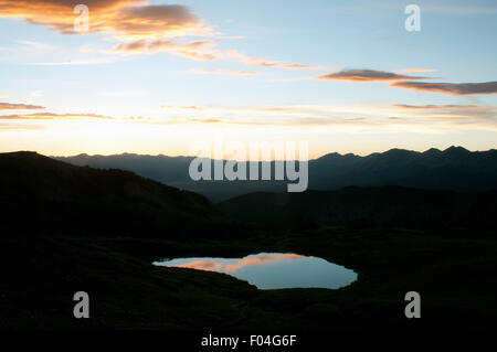 Un alpine tarn riflette la luce della sera come al tramonto si deposita sopra la valle di Gunnison come visto da pioppi neri americani passano vicino a Buena Vista, Colorado. Foto Stock