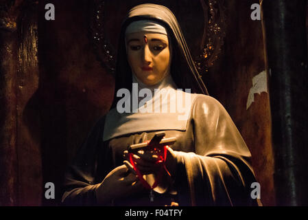 Statua di Santa Rita di Cascia la Iglesia de la Merced Panama City // PANAMA CITY, Panama — Una statua di Santa Rita di Cascia si trova all'interno della Iglesia de la Merced nello storico quartiere casco Viejo di Panama City. Nota come la "Santa delle cause impossibili", Rita (1381-1457) fu una suora agostiniana italiana canonizzata nel 1900 ed è spesso invocata per difficoltà coniugali e situazioni apparentemente senza speranza. La chiesa, risalente al XVII secolo, era una delle poche strutture trasferite pietra per pietra dall'originale Panama City (Panama Viejo) dopo che fu distrutta dal pirata Henry Morgan nel 167 Foto Stock