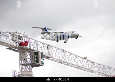 Cityjet Dornier 328-110 in atterraggio a City Airport London dietro di gru a torre galeoni a raggiungere lo sviluppo, Docklands Foto Stock