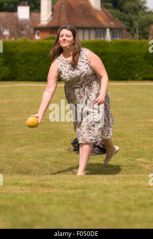 Donna che gioca il melone bowling in un paese equo, Selborne, Hampshire, Regno Unito. Foto Stock