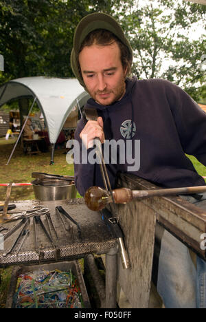 Glassblower al lavoro la sagomatura di vetro che è stato riscaldato a circa 1100C, la vita rurale centro, Tilford, Surrey, Regno Unito. Foto Stock