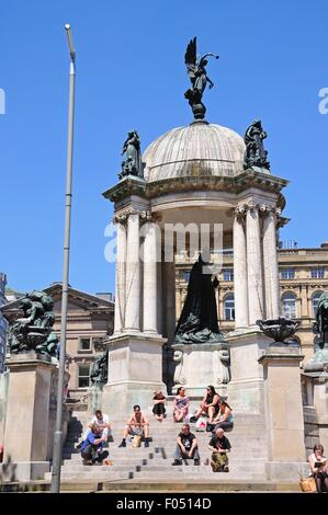 La regina Victoria monumento nel Derby quadrato con turisti che si siedono sui gradini godendo il sole estivo, Liverpool, Regno Unito. Foto Stock