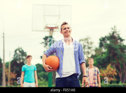 Un gruppo di ragazzi sorridenti giocare a basket Foto Stock