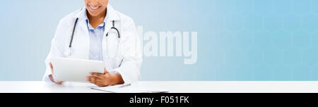 Felice medico africano con tablet pc su blu Foto Stock