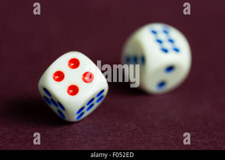 Una coppia di dadi in movimento su un concetto che suggerisce una mancanza di chiarezza quando si scattano le possibilità. Foto Stock