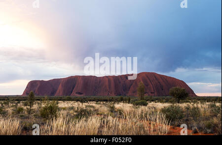 Australia, Ayers Rock, nuvoloso tramonto su Uluru la montagna sacra Foto Stock