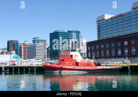 Red rimorchiatore porto, edifici per uffici e il CBD dietro, Wellington, Isola del nord, Nuova Zelanda Foto Stock