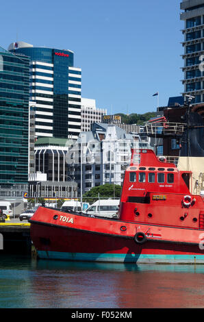 Red rimorchiatore porto, edifici per uffici e il CBD dietro, Wellington, Isola del nord, Nuova Zelanda Foto Stock