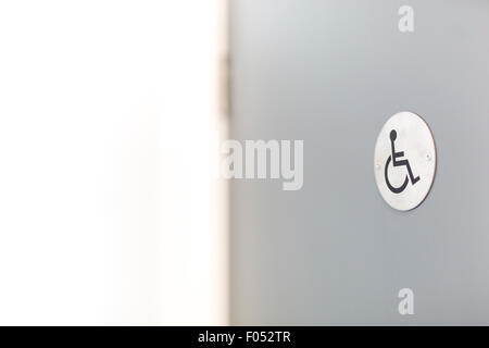 In sedia a rotelle Accesso disabili su una porta di toilette Foto Stock