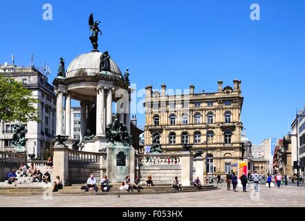 La regina Victoria monumento nel Derby quadrato con turisti che si siedono sui gradini godendo il sole estivo, Liverpool, Regno Unito. Foto Stock