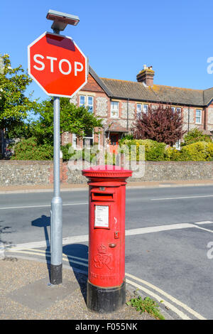 Red letter box. Royal Mail King George VI rosso Casella Montante sull'angolo di una strada con un semaforo con un segno di stop in Inghilterra, Regno Unito. Foto Stock