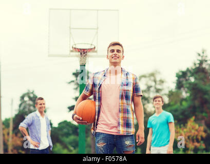 Un gruppo di ragazzi sorridenti giocare a basket Foto Stock