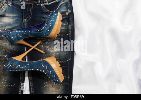 Glamour moda femminile, jeans e scarpe in strass, giacente su bianco seta Foto Stock