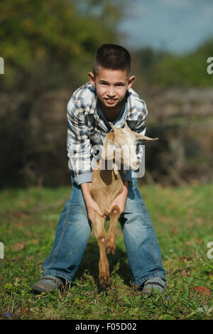 Little Boy con capra in azienda Foto Stock