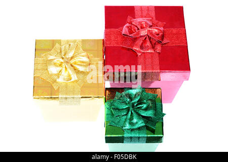 Tre confezioni regalo di diversa dimensione e colore isolato su bianco Foto Stock