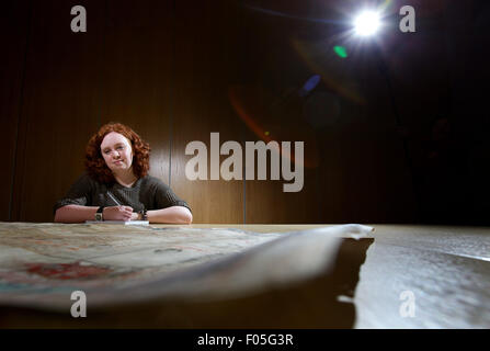 Archeologia femmina studente di antiche mappe Foto Stock