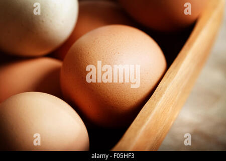 Rosolare le uova in una ciotola di legno su una tavola di legno Foto Stock