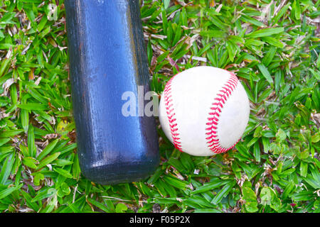 Mazza da baseball e la sfera posa su erba verde all'aperto Foto Stock