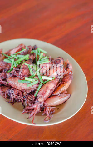 Piastra del saltata di piccoli calamari fritti con aglio e salsa Foto Stock