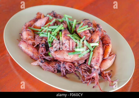 Piastra del saltata di piccoli calamari fritti con aglio e salsa Foto Stock