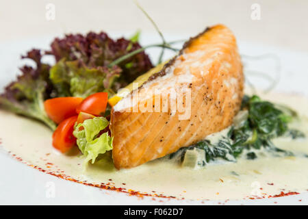 Pezzo di bistecca di salmone con verdure che serve al ristorante Foto Stock