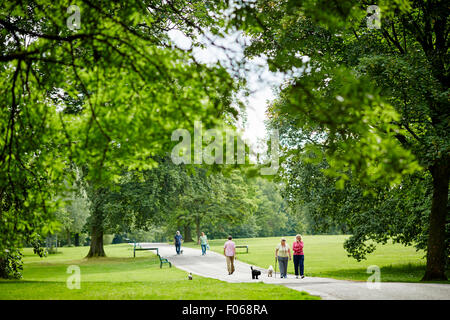 Woodbank Memorial Park in Offerton, Stockport, Regno Unito. Dog walkers nel parco Foto Stock