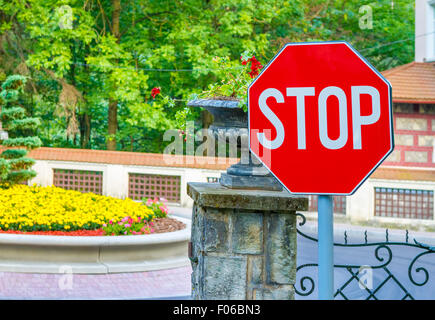 Il segnale di arresto closeup con boschi e recinzione in background. Foto Stock