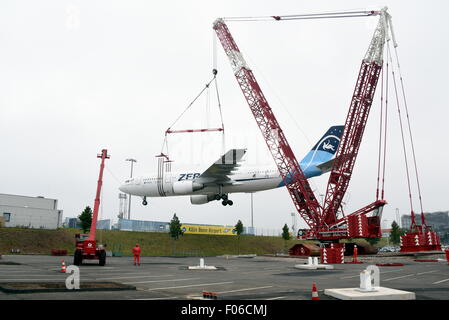 Un piano di Airbus tipo A 300 viene sollevato da un 60-metro-alta gru su di un area di parcheggio all'aeroporto di Colonia-Bonn, Germania, 8 agosto 2015. L'Airbus A300 ZERO-G è stato usato fino al 2014 dalla nazionale tedesco di ricerca aeronautica e spaziale centro 'DLR" a prova di gravità zero, in autunno sarà utilizzato come un aeroplano interattivo nel museo. Foto: Horst Galuschka - nessun filo SERVICE - Foto Stock