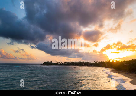 Golden tramonto sulla spiaggia deserta con colorati sky e scenic cloudscape durante il monsone di tempo. Complesso turistico di Unawatuna, Sri Lank Foto Stock