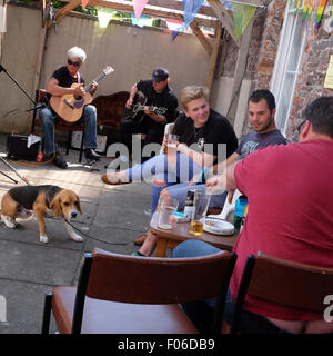 Brecon, Powys, Wales, Regno Unito. Aug, 2015. Le persone godono di una birra come essi ascoltare musica dal vivo in un pub birreria come parte del Brecon Jazz e Brecon Fringe Festival weekend. Foto Stock