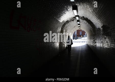 Una donna che cammina da solo attraverso un tunnel su Leeman Road, York, North Yorkshire, Regno Unito. Immagine: Scott Bairstow/Alamy Foto Stock