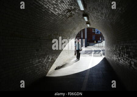 Una donna che cammina da solo attraverso un tunnel su Leeman Road, York, North Yorkshire, Regno Unito. Immagine: Scott Bairstow/Alamy Foto Stock