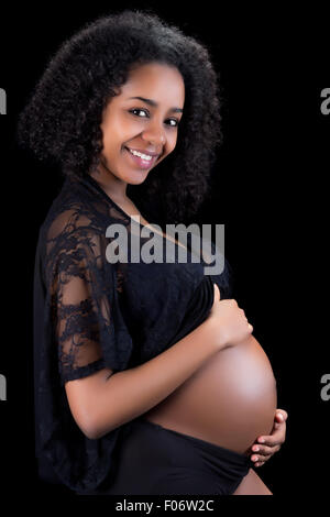 Sorridenti african donna incinta indossando pizzo nero Foto Stock