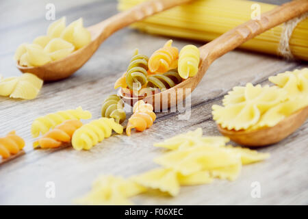 Tre tipi di pasta in cucchiai di legno sul tavolo Foto Stock