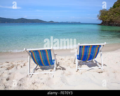 Colorate sedie a sdraio sulla spiaggia di sabbia bianca Foto Stock