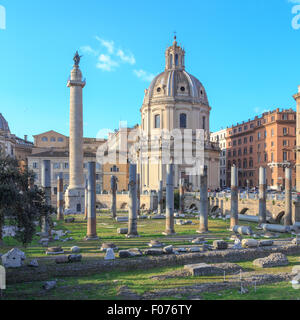 Vista attraverso le antiche rovine del Foro di Traiano verso la Colonna di Traiano a Roma, Italia. Foto Stock