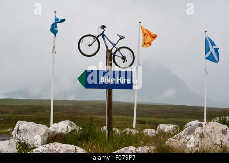 Noleggio bici a firmare all'entrata di Glencoe Mountain Resort, Glencoe, Scozia, con la nuvola coprì Buachaille Etive Mor dietro Foto Stock