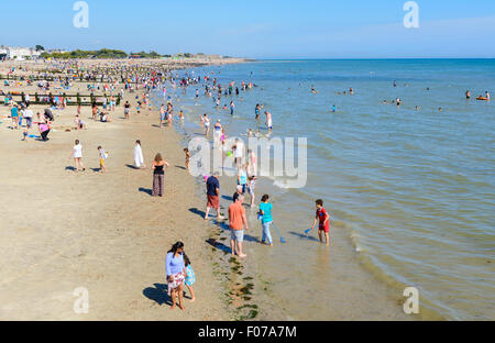 La gente di nuoto in mare ad una spiaggia un giorno d'estate al mare in Littlehampton, West Sussex, in Inghilterra, Regno Unito. Foto Stock