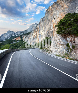 Strada asfaltata nel bosco estivi al tramonto. Montagne di Crimea. Foto Stock