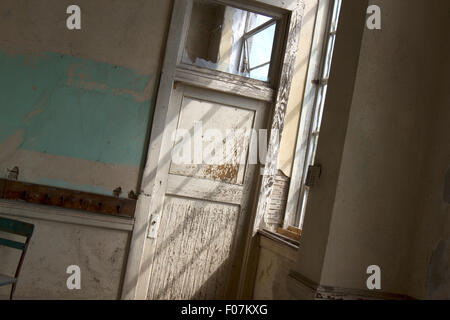 La luce che arriva attraverso il vetro rotto nella vecchia scuola camera. Foto Stock