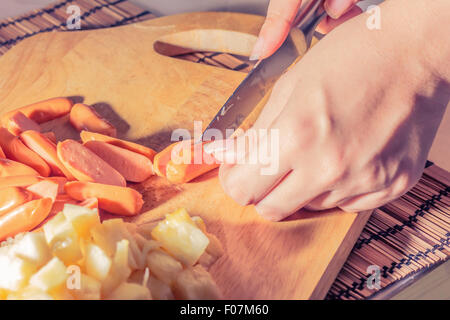 Preparazione di una stir fry di legumi stufati e salsiccia Foto Stock