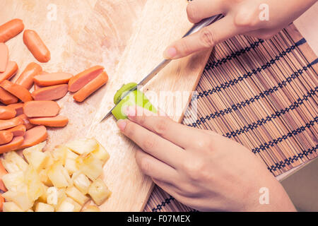 Preparazione di una stir fry di legumi stufati e salsiccia Foto Stock