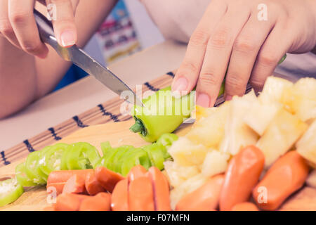 Preparazione di una stir fry di legumi stufati e salsiccia Foto Stock